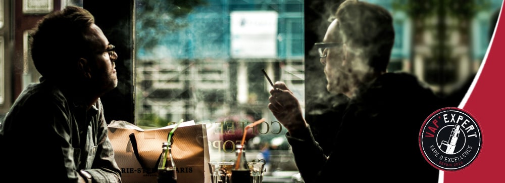 Image representant l'addiction comportementale de la cigarette classique via deux individus qui fument autour d'une table dans un bar.